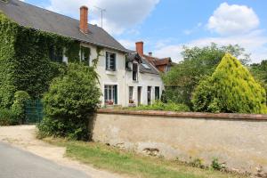 a white house with ivy growing on the side of it at Le Clos de Châtres in Oisly