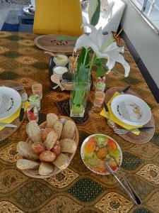 a table with plates of food and a vase with a flower at Loc de cabines sur Yacht in Gruissan