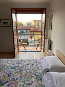 Un dormitorio con una cama y vista a un balcón. en Casa Maira in centro a Bra, en Bra