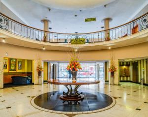 a large lobby with a table with flowers on it at Bulawayo Rainbow Hotel in Bulawayo