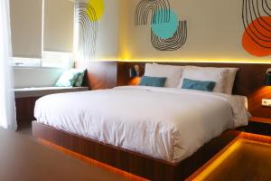 ein Schlafzimmer mit einem großen weißen Bett in einem Zimmer in der Unterkunft Stay G Service Residence Jatibening in Kaliastana