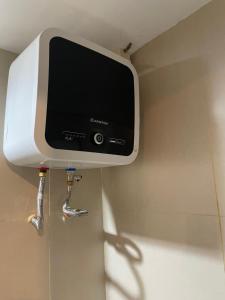 a tv on the corner of a wall in a bathroom at Stay G Service Residence Jatibening in Kaliastana