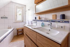 a white bathroom with a sink and a tub at Ferienhaus Ankerherz in Wustrow