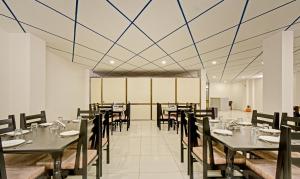 a dining room with tables and chairs and a ceiling at Treebo Paras Raj Near City Palace in Udaipur