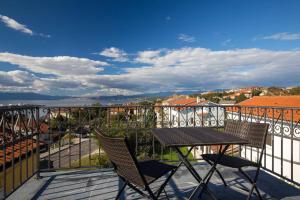 una mesa y sillas en un balcón con vistas en Villa Ajda - Green room en Omišalj