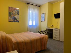 a bedroom with a bed and a desk with a computer at Hotel Giardino in Pieve di Cadore