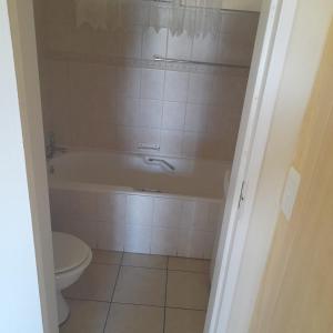 a bathroom with a bath tub and a toilet at 102 Santana Holiday Resort in Margate +12 photos