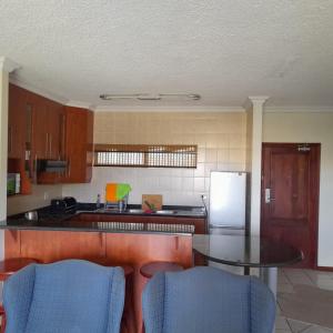 a kitchen with a table and a refrigerator at 102 Santana Holiday Resort in Margate