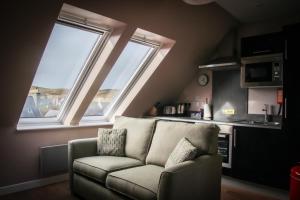 a living room with a couch and two windows at Nort Bode Apartments in Lerwick