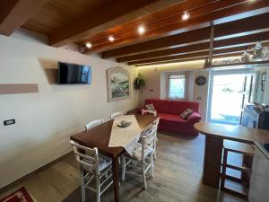 - un salon avec une table et un canapé rouge dans l'établissement Casa Vallenari, à Selvavecchia