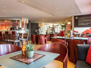 a restaurant with brown chairs and tables and a bar at ibis Antwerpen Centrum in Antwerp