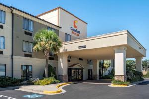 a hotel with a palm tree in a parking lot at Comfort Suites Mobile West/Tillmans Corner in Mobile