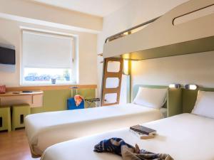 a bedroom with two beds and a bunk bed at ibis budget Antwerpen Centraal Station in Antwerp