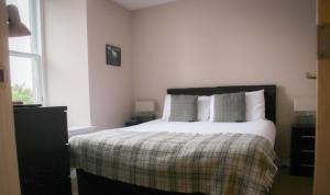 een slaapkamer met een bed en een raam bij Nort Bode Apartments in Lerwick