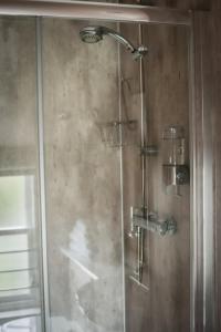 a shower with a glass door in a bathroom at Nort Bode Apartments in Lerwick