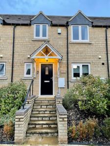 a brick house with a staircase leading to a door at Lion Cottage, Broadway in Broadway