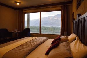 a bed in a room with a large window at Baltistan Fort in Skardu