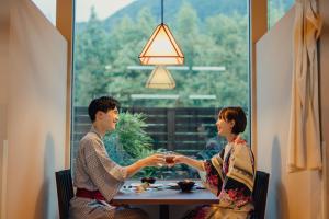 a man and woman sitting at a table holding hands at SEKIYA RESORT Terrace Midoubaru in Beppu