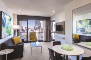 a living room with a couch and a table at Adina Apartment Hotel Melbourne in Melbourne