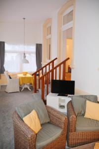 a living room with two chairs and a television at Ferienhaus Pauls Ferienhaus Pauls, Whg 02 in Norderney