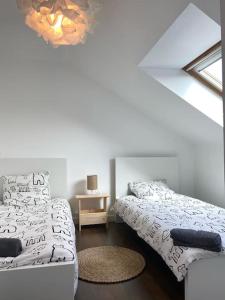 um quarto branco com duas camas e uma mesa em Malo les bains: duplex à deux pas de la plage. em Dunkerque