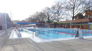 an empty swimming pool with a ramp and a sign at Beautiful apartment right off of Broadway Market in London