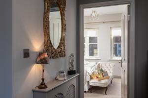 a bedroom with a mirror and a chair and a bed at Sugar Reef - A Fantastic Modern House with Garden, Free Parking for 2 cars, Electric Vehicle Point, Whitby Beach, Shops, Bars, Restaurants just a 10 minute walk away, Maximum Occupancy 4 Guests in Whitby