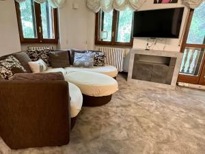 a living room with couches and a flat screen tv at Insieme è più bello in Sauze dʼOulx