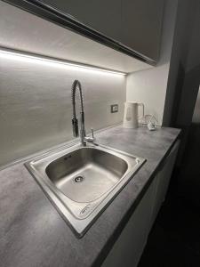 a stainless steel sink in a kitchen with a light at Insieme è più bello in Sauze dʼOulx +9 photos
