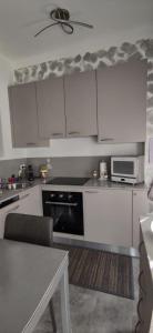 - une cuisine avec des placards blancs, un four micro-ondes et une table dans l'établissement sommacon house, à Sanremo