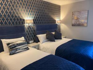 two beds in a hotel room with blue and white at Ardboyne Hotel in Navan