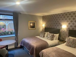 a hotel room with two beds and a window at Ardboyne Hotel in Navan