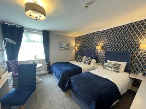 a hotel room with two beds and a chair at Ardboyne Hotel in Navan