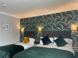 a hotel room with two beds with green and yellow pillows at Ardboyne Hotel in Navan