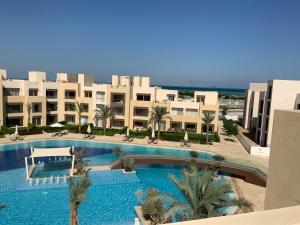 a large swimming pool with palm trees and buildings at Elgouna Hurghada egypt mangroovy in Hurghada