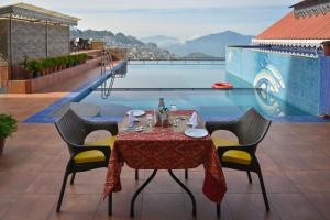 a dining table and chairs with a view of a pool at Sinclairs Gangtok in Gangtok