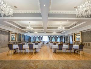 a banquet hall with white tables and chairs and chandeliers at Ardboyne Hotel in Navan