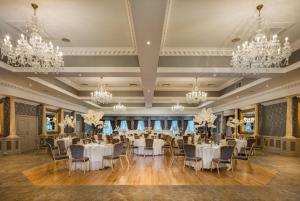 a banquet hall with white tables and chairs and chandeliers at Ardboyne Hotel in Navan
