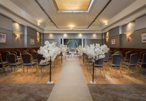 a row of tables and chairs in a room with white flowers at Ardboyne Hotel in Navan