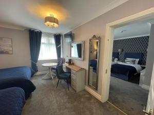 a room with two beds and a desk and a mirror at Ardboyne Hotel in Navan