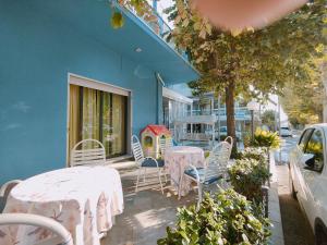 a patio with tables and chairs and a house at Hotel Marittimo in Rimini