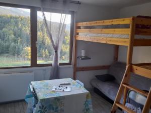 a bedroom with a bunk bed and a table and a chair at les glovettes Villard de lans in Villard-de-Lans