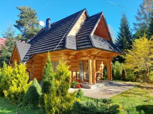 a log cabin with a gambrel roof at BIAŁY PUCH in Zakopane