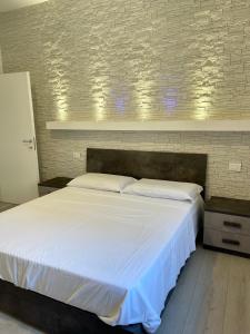 a bedroom with a large bed with white sheets at Melissa in Belluno