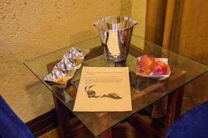 a glass table with a plate of fruit and a sign on it at Baltistan Fort Skardu Resort in Skardu