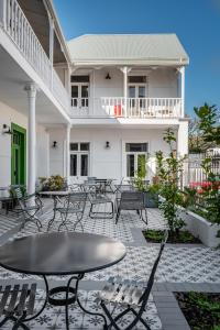 a patio with tables and chairs in front of a house at iGadi House Boutique Hotel in Cape Town