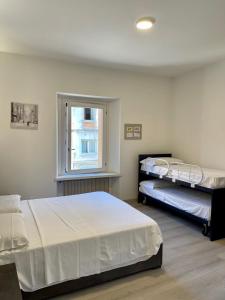 1 dormitorio con 2 camas y ventana en Melissa, en Belluno