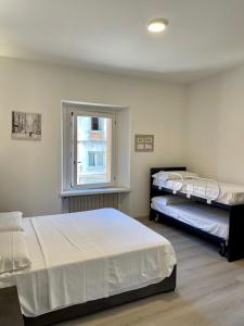 a bedroom with two beds and a window at Melissa in Belluno