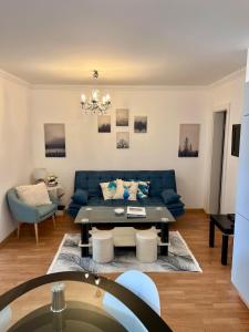 ein Wohnzimmer mit einem blauen Sofa und einem Tisch in der Unterkunft MaHome Apartments in Lofer