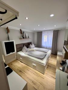 a bedroom with a bed and a flat screen tv at MaHome Apartments in Lofer